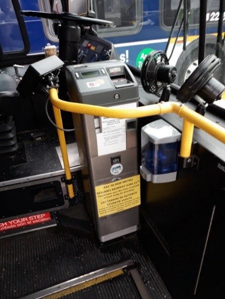 Farebox with sanitizer dispenser at front of bus
